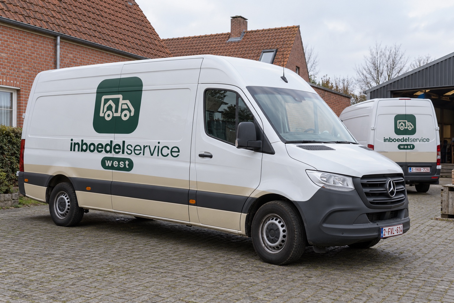 Sfeerbeeld van twee witte camionetten met de groene belettering van Inboedelservice West